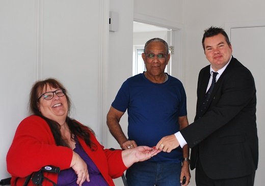 Mr and Mrs Colepil accepting the keys to their new home from Councillor Robert Benham, Deputy Leader of Havering Council