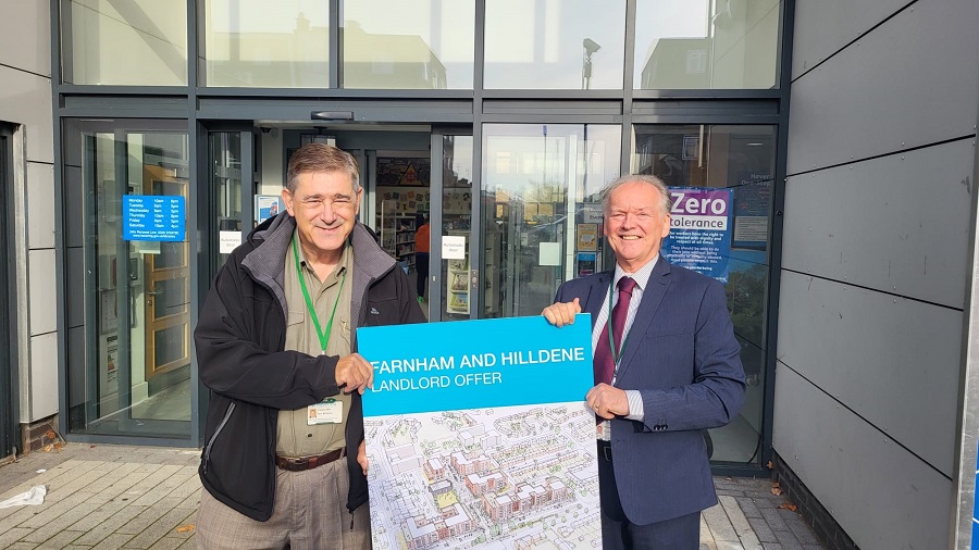 Councillor Paul McGeary and Councillor Graham Williamson hold a board showing the front cover of the Landlord Offer outside the Harold Hill Library