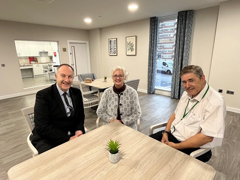 Photo shows Eileen, smiling, with Cllr Ray Morgon to the left of the image in a dark suit, and Cllr Paul McGeary in a white shirt, to the right. All smiling at the camera.