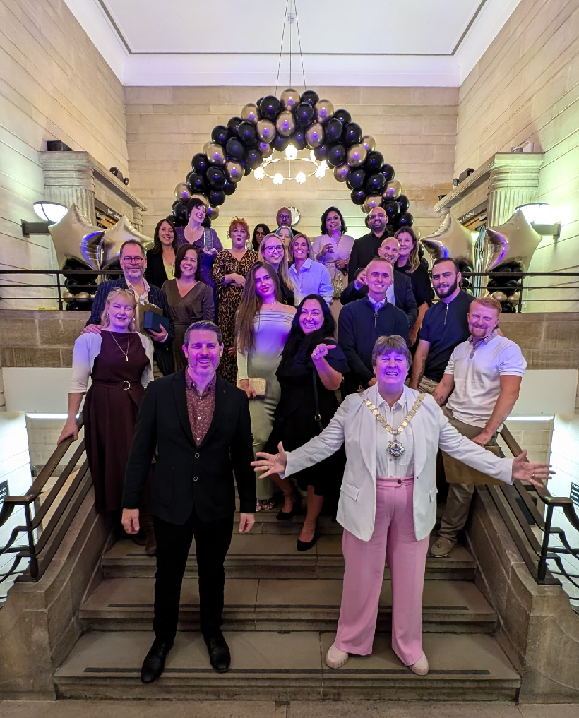 Group photo on stairs with balloon arch in background