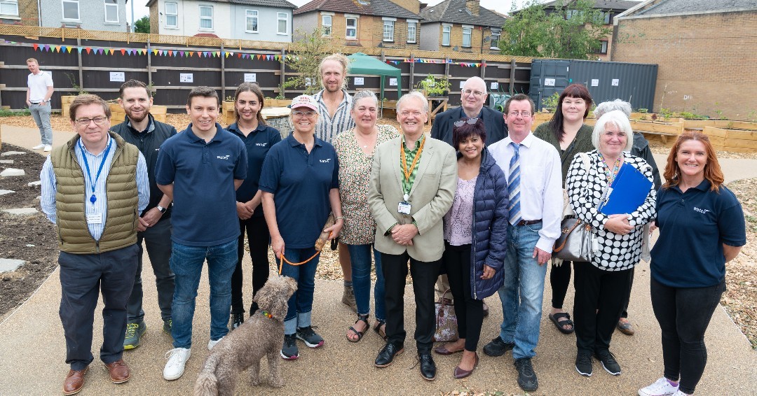 Image shows councillors and residents smiling in the community garden